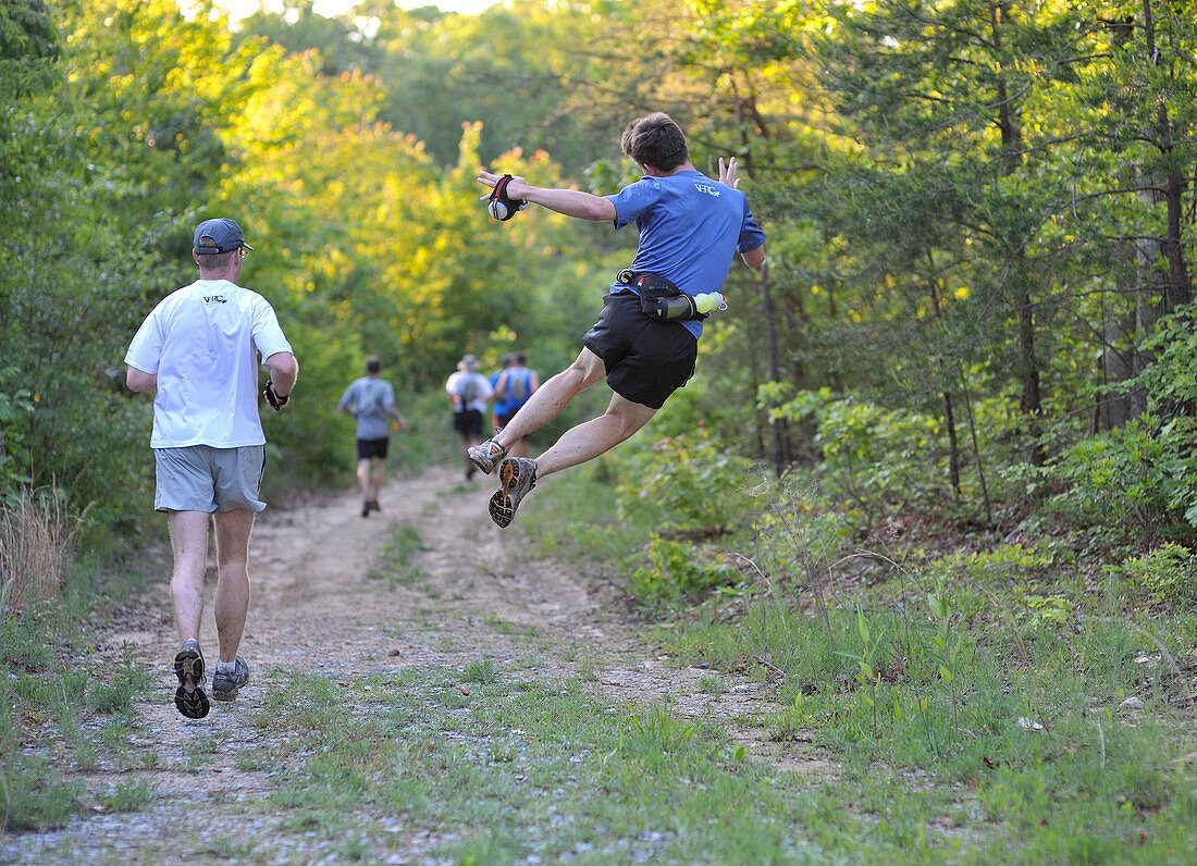 People Running On Trail In Forest