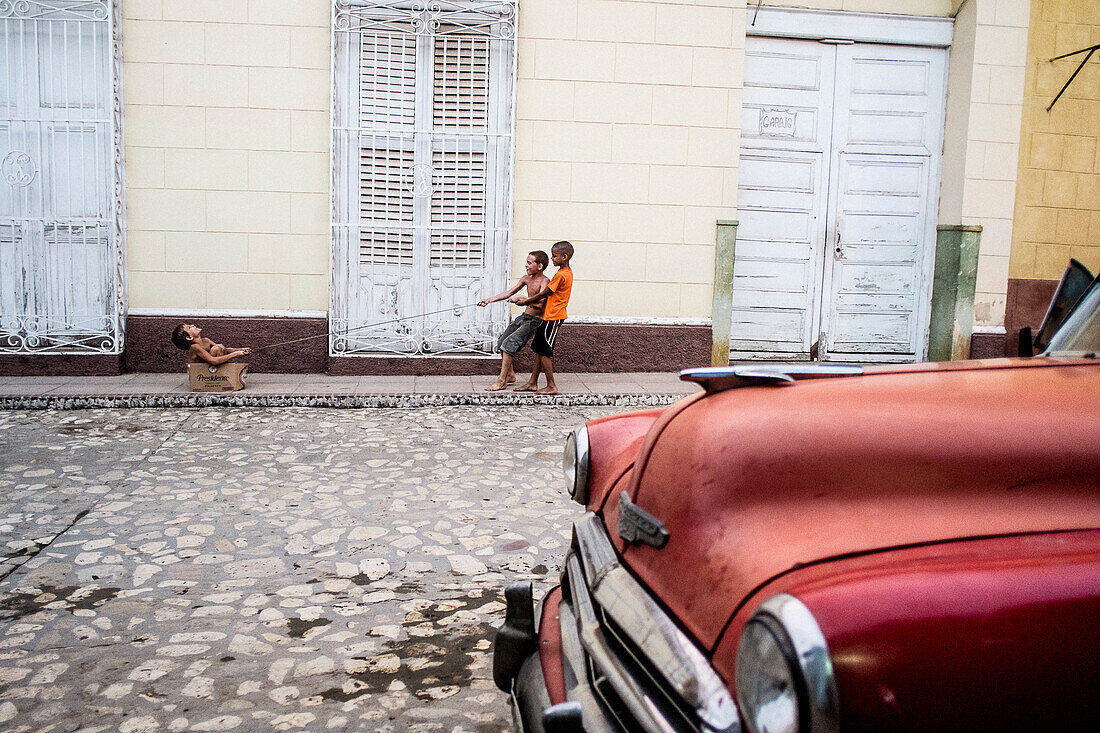 Three kids play on the street in Trinidad, Cuba