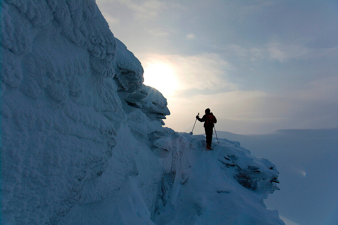A man Climbing Trollstein, a frozen peak in Spitzbergen, Svalbard, Norway