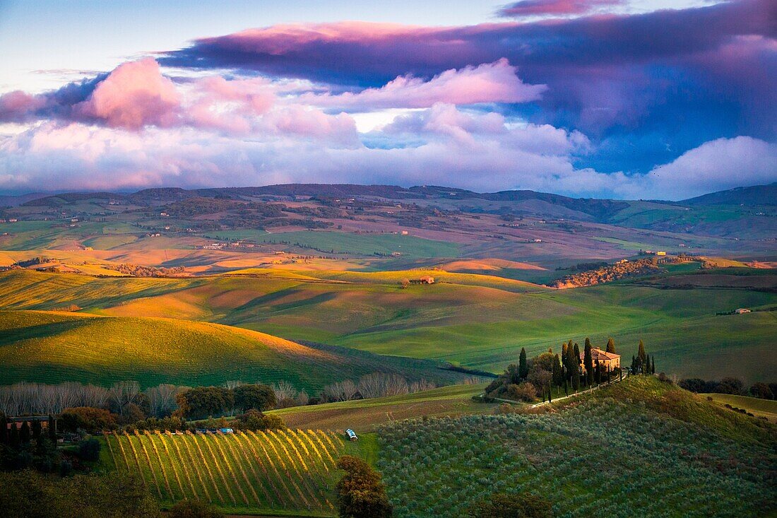 San Quirico d'Orcia, Tuscany, Italy Sunset over the valley with some farmhouses and a very cloudy sky