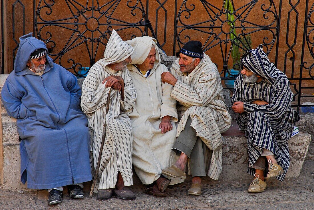 Old local men dressed with chilabas or djellabas (bereber clothes) at the heart of the central square, Outa el Hammam, Chefchaouen or Chaouen, Rif Region, Morocco, North Africa