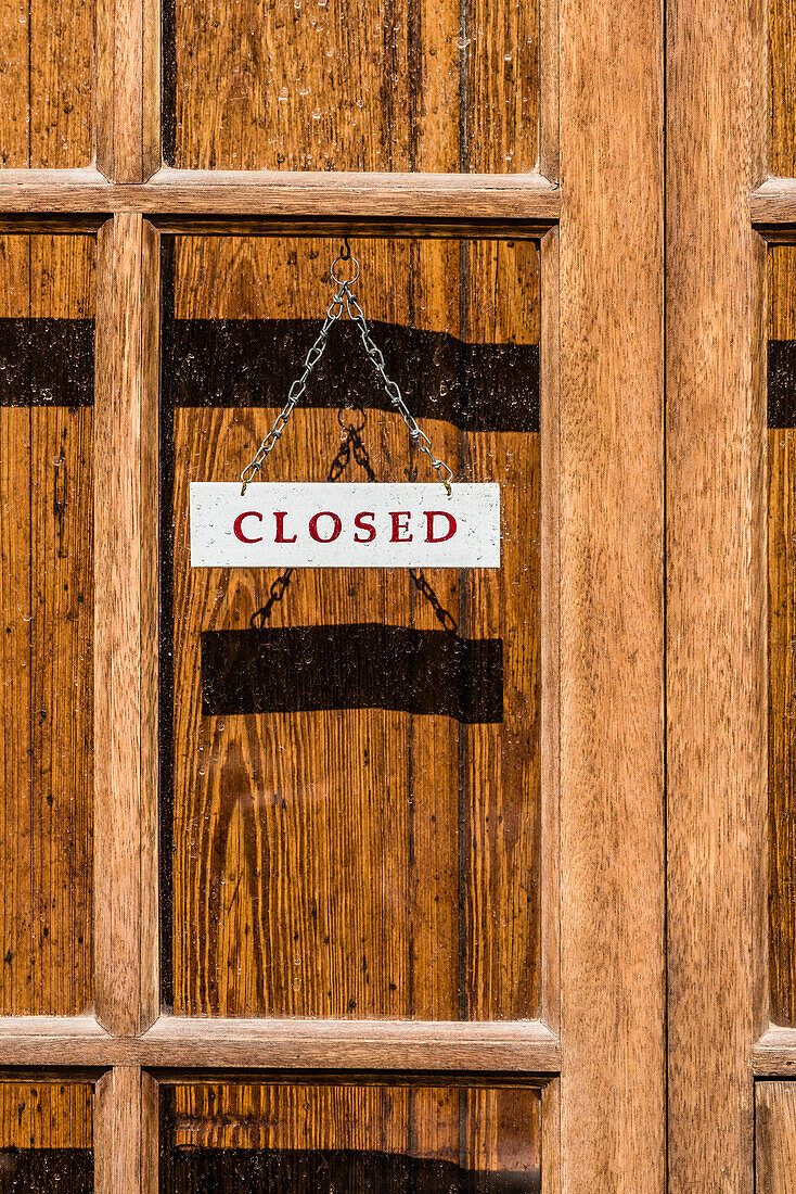 ' A ''closed sign'' at a store with wooden door in the low season, Port de Sóller, Mallorca, Spain'