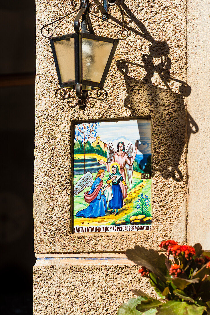 Beside many front doors you find tiles with representations from the life of the island saint Catalina Thomás, Valldemossa, Mallorca, Spain