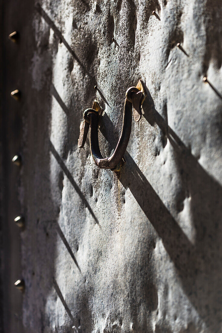 Ein Türklopfer aus Metall an einer alten metallenen Eingangstür, Fornalutx, Mallorca, Spanien
