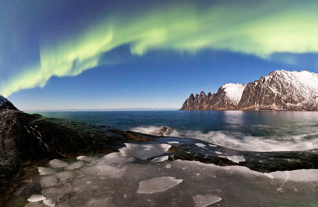 Panorama von gefrorenem Meer und felsigen Gipfeln, beleuchtet von den Nordlichtern (Aurora Borealis), Tungeneset, Senja, Troms, Norwegen, Skandinavien, Europa