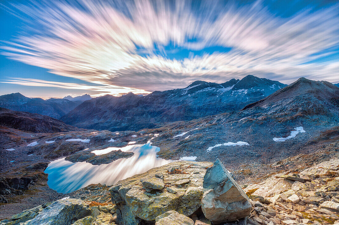 Die Wolken im Morgengrauen spiegeln sich in Lai Ghiacciato umrahmt von Gipfeln, Val Ursaregls, Chiavenna-Tal, Valtellina, Lombardei, Italien, Europa