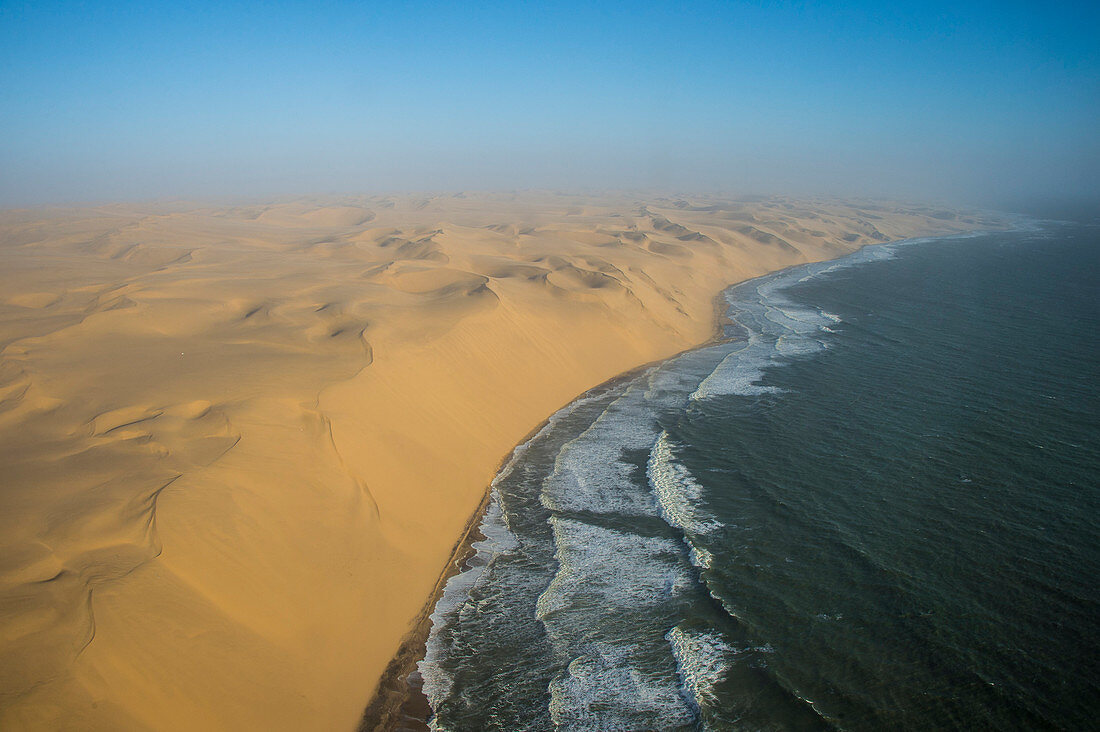 Luftaufnahme von Sanddünen der Namib-Wüste, die den Atlantischen Ozean, Namibia, Afrika treffen