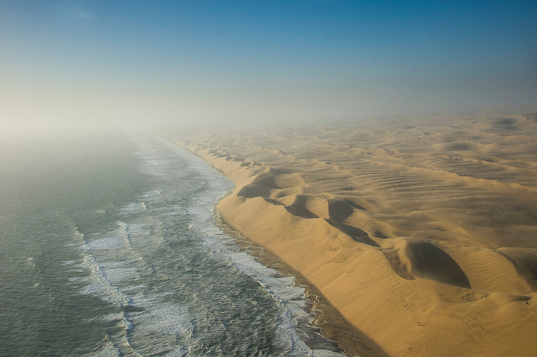 Aerials of sand dunes of the Namib Desert meeting the Atlantic Ocean, Namibia, Africa