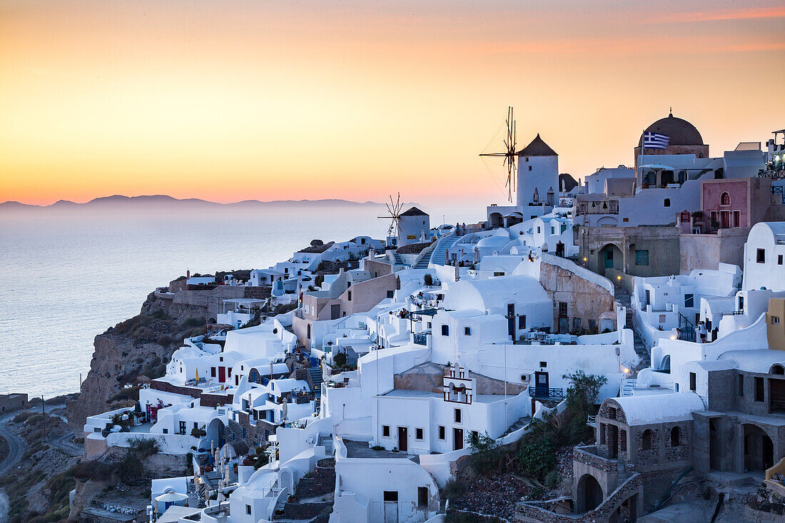 Sunset view over the whitewashed buildings and windmills of Oia from the castle walls, Santorini, Cyclades, Greek Islands, Greece, Europe