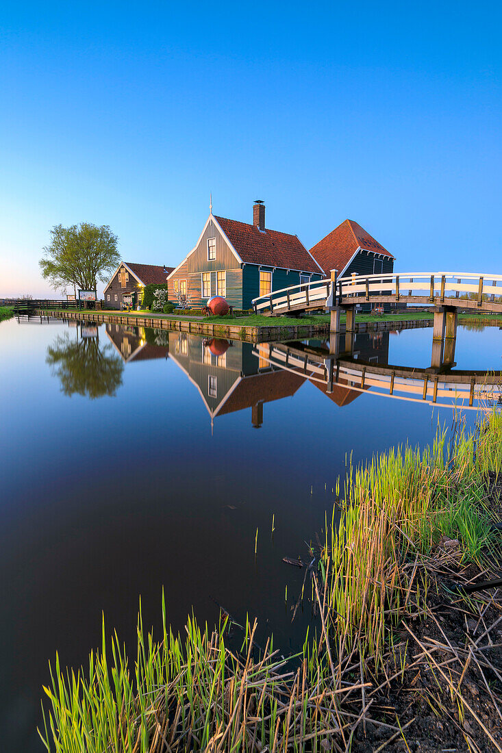 Blaue Dämmerung auf Holzhäusern des typischen Dorfes Zaanse Schans umrahmt von Zaan, Zaanse Schans, Nordholland, Niederlande, Europa