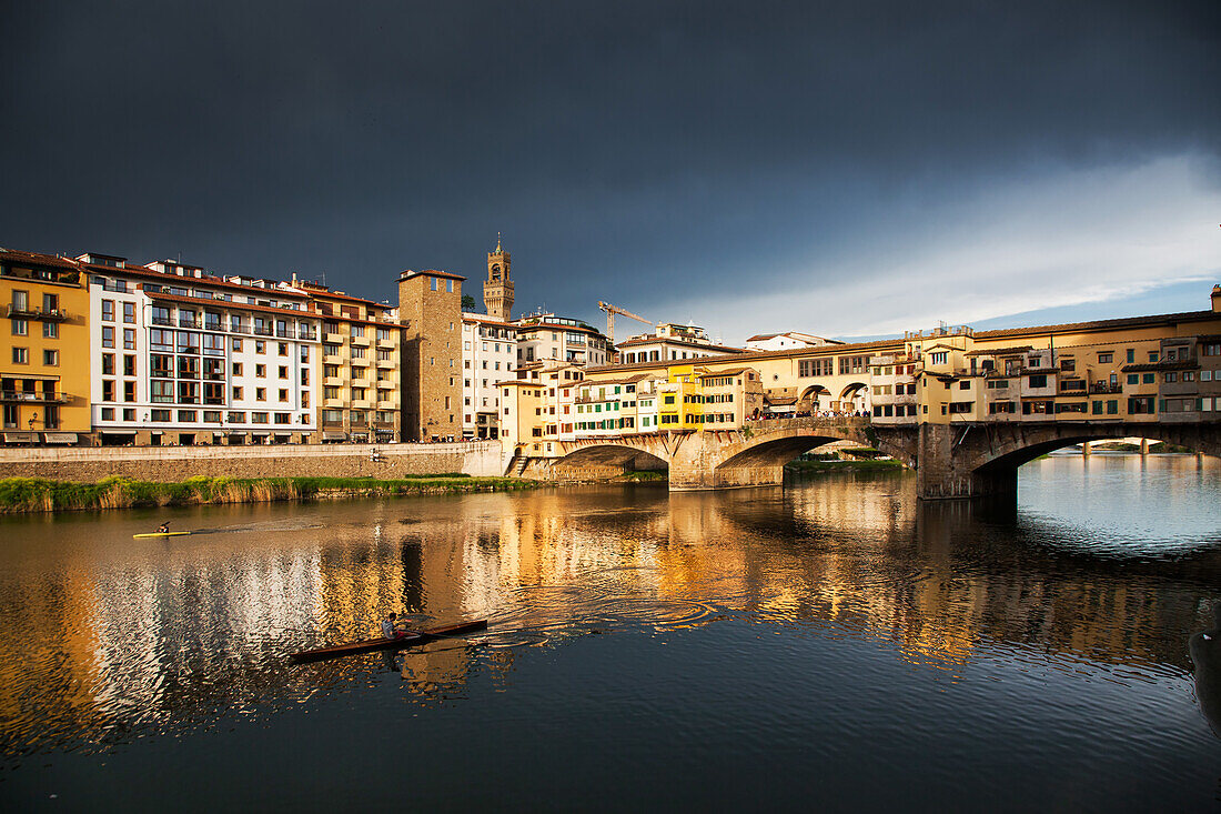 Ponte Vecchio spiegelt sich im Arno gegen einen dunkelblauen stürmischen Himmel, Florenz, UNESCO Weltkulturerbe, Toskana, Italien, Europa
