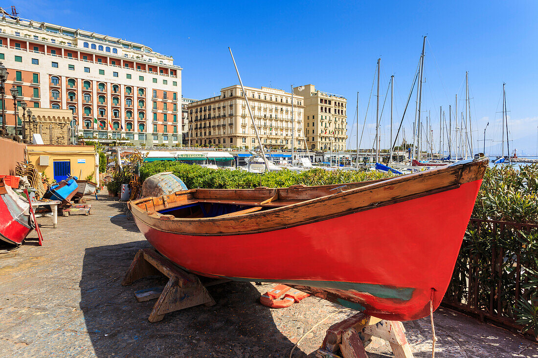 Bunte Ruderboote unter Reparatur an der Marina Borgo Marinaro, mit Kulisse der Grand Hotels, Chiaia, Stadt Neapel, Kampanien, Italien, Europa