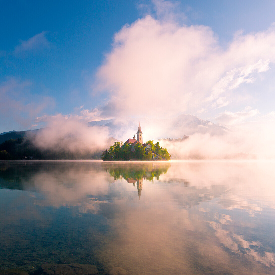 Bled See, Slowenien, Ein magischer und unvorhergesehener Sonnenaufgang über der nebligen Insel