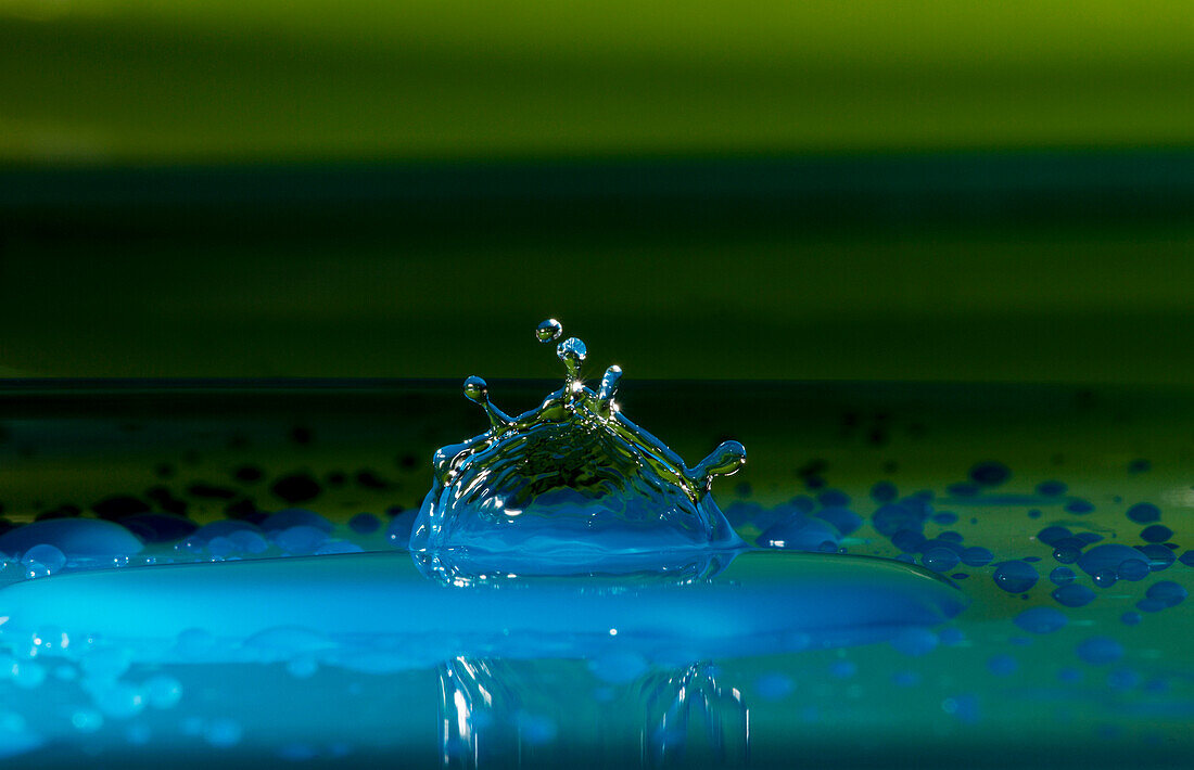 Ein Makro-Stillleben der Form, dass es einen Tropfen Wasser nach dem Aufprall mit einer Oberfläche annimmt