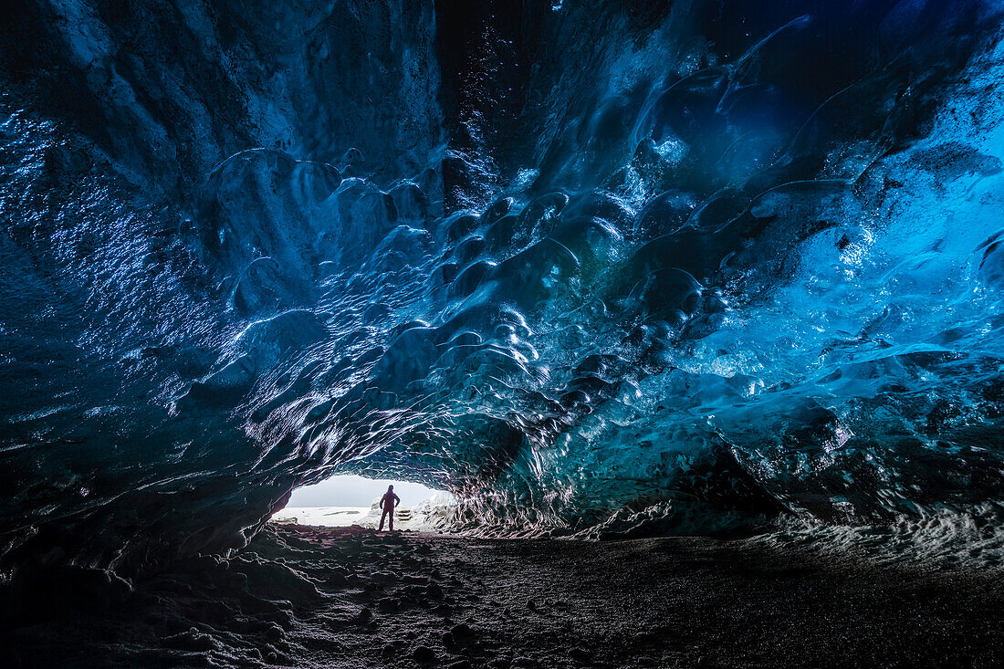 Man inside an ice caver under the Vatnajokull glacier, Vatnajokull national park, East Iceland, Iceland , MR