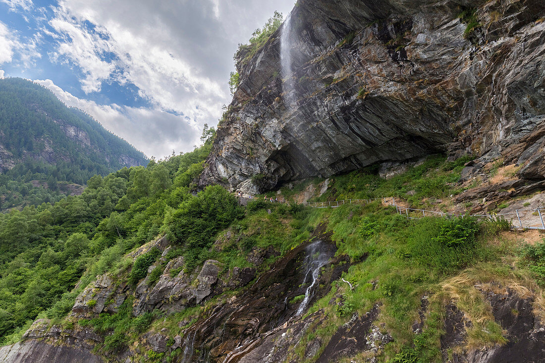 Catwalk under a waterfall on the trail around Lago di Antrona, Valle Antrona, Piedmont, Italy