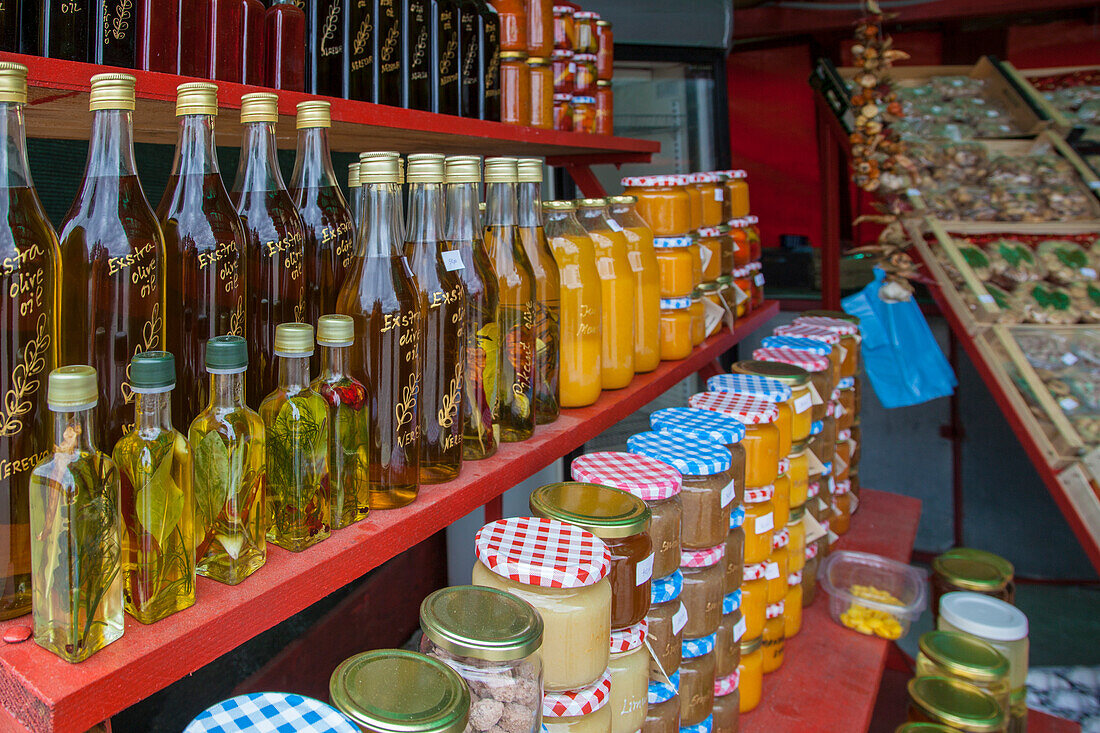 Bottles of olive oil, marmalade, honey, for sale in a market of local products along the road near Komin, Croatia