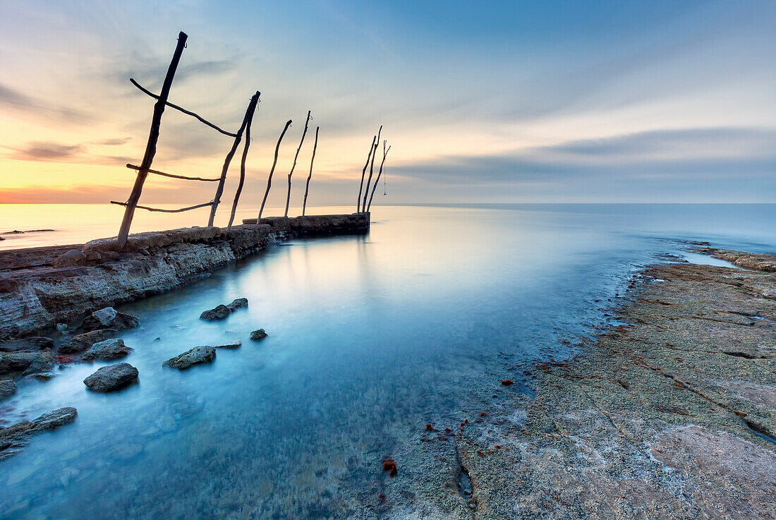 Europa, Kroatien, Istrien, Adriaküste, Umag, Dorf Savudrija, Die Bucht bei Sonnenuntergang mit traditionellen Holzstangen für Fischerboote