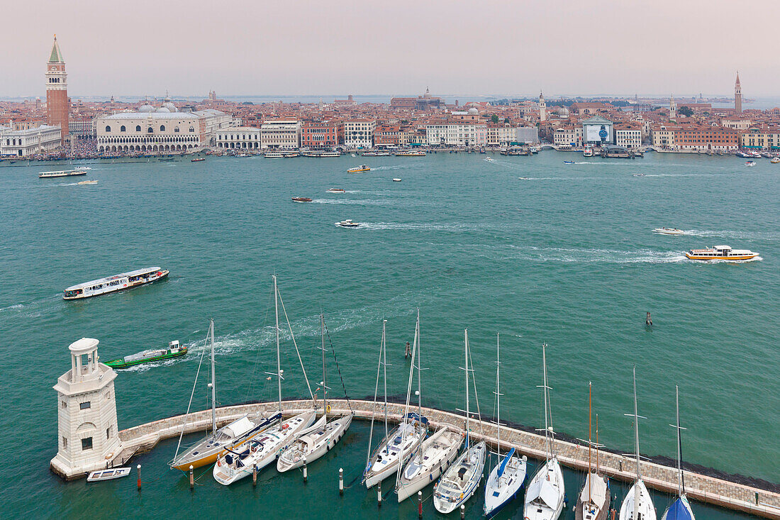 Europa, Italien, Venetien, Insel San Giorgio Maggiore, Einer der Scheinwerfer des Docks und einige festgemachte Boote, auf dem Hintergrund St, Mark und das historische Zentrum von Venedig