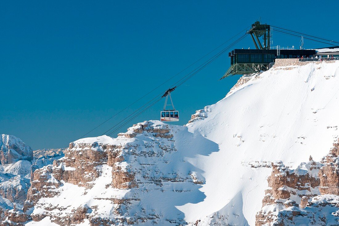 The cable car of Sass Pordoi between the high snowy peaks of the Dolomites Canazei Val Di Fassa Trentino Italy Europe