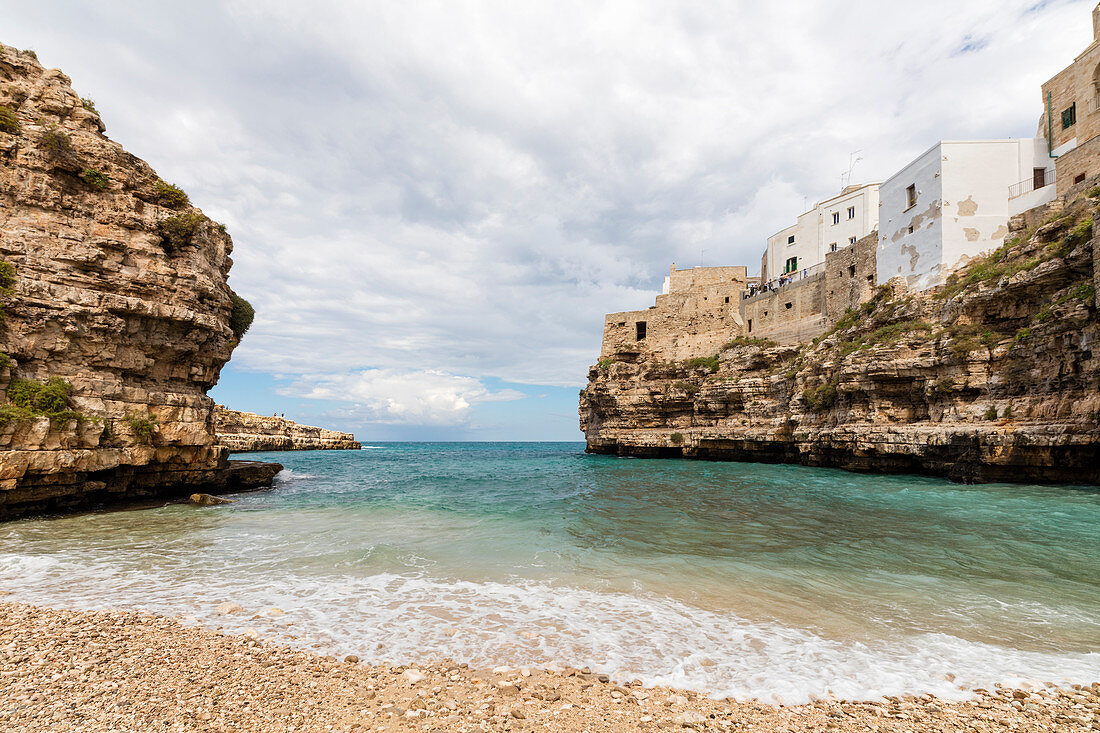 Turquoise sea framed by the old town perched on the rocks Polignano a Mare province of Bari Apulia Italy Europe