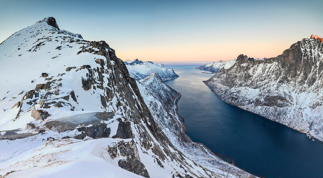 Panorama of snowy mountains and icy sea surrounding Peak Barden at sunset Ornfjorden Fjordgard Senja Tromsø Norway Europe