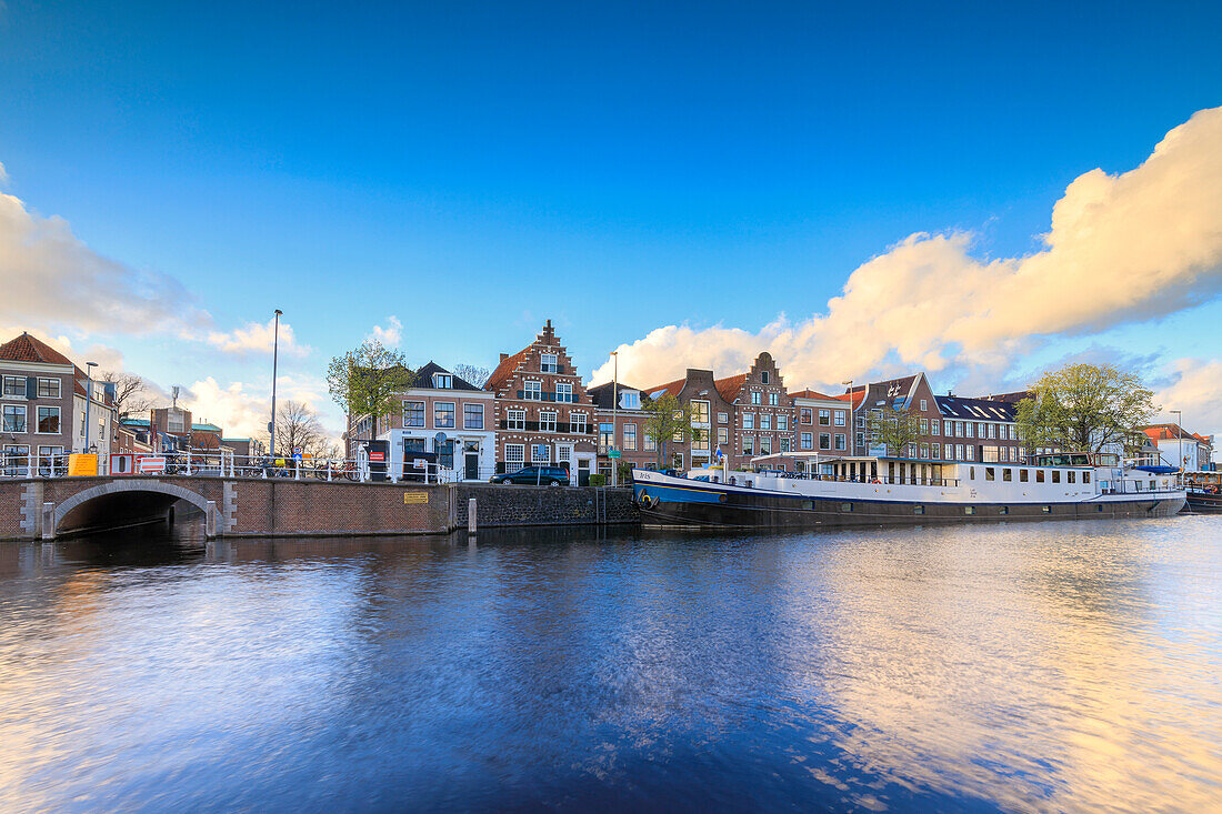Blauer Himmel und Wolken auf typischen Häusern spiegelt sich im Kanal des Flusses Spaarne Haarlem Nordholland Niederlande Europa