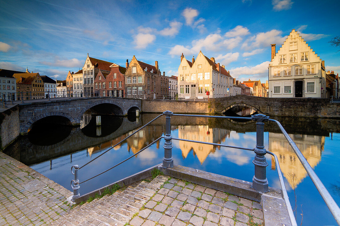 Blick auf die typischen Gebäude spiegelt sich auf dem Kanal bei Sonnenaufgang von einer Terrasse auf dem Kai Brügge Westflandern Belgien Europa