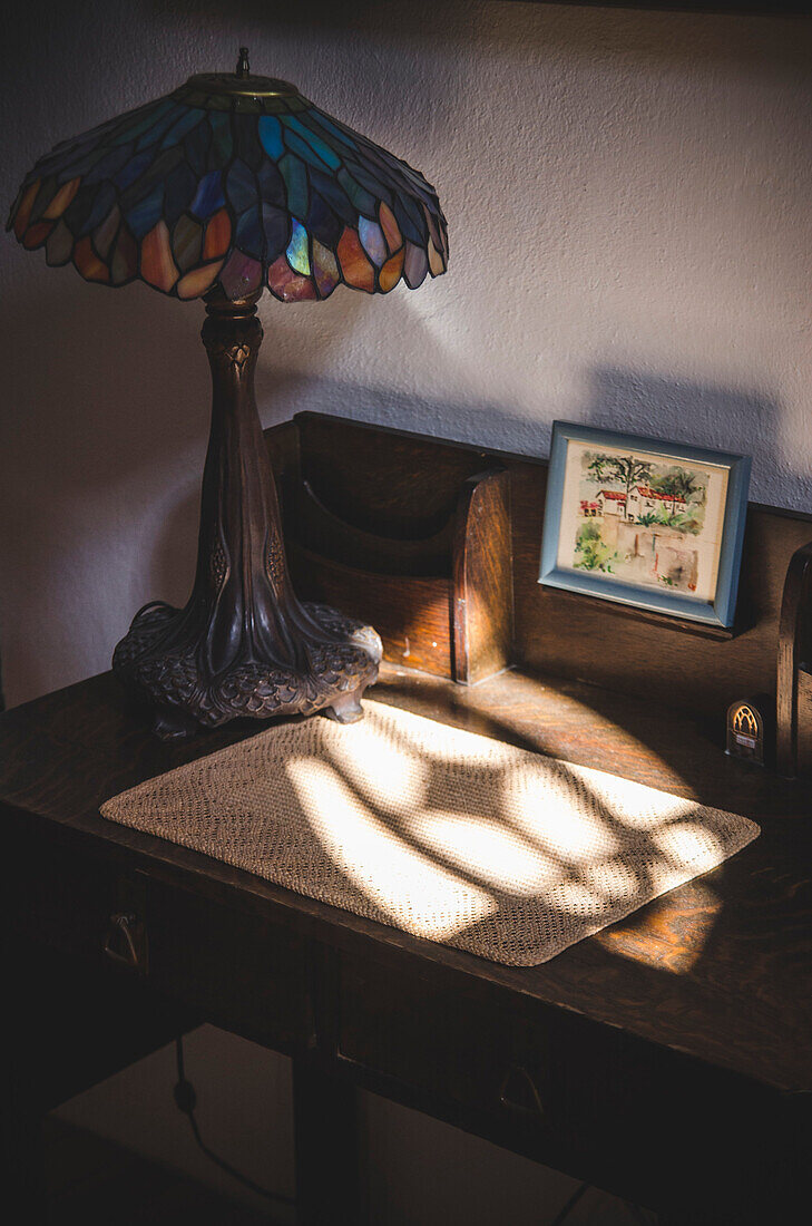 Licht vom Fenster auf kleinem Schreibtisch mit Lampe im Schatten