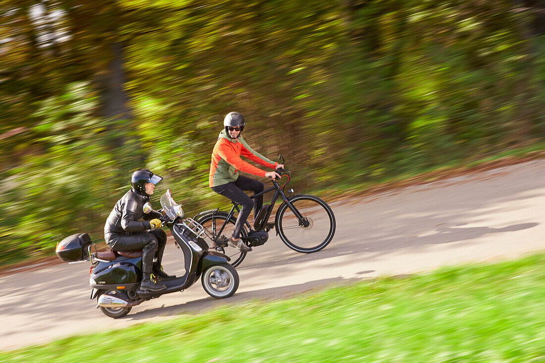 eBike Fahrer im Duell mit Vespa, Münsing, Oberbayern, Deutschland