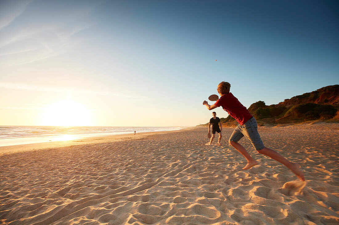 two boys playing beachball on the beach, Spain; andalusia; atlantic; coast; europe; woman; stairs; beach; evening'