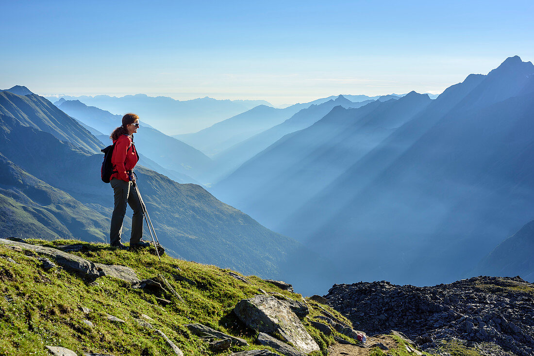 Woman hiking looking towards valley of Unterbergtal, Stubai highroute, Grosser Troegler, Stubai Alps, Tyrol, Austria