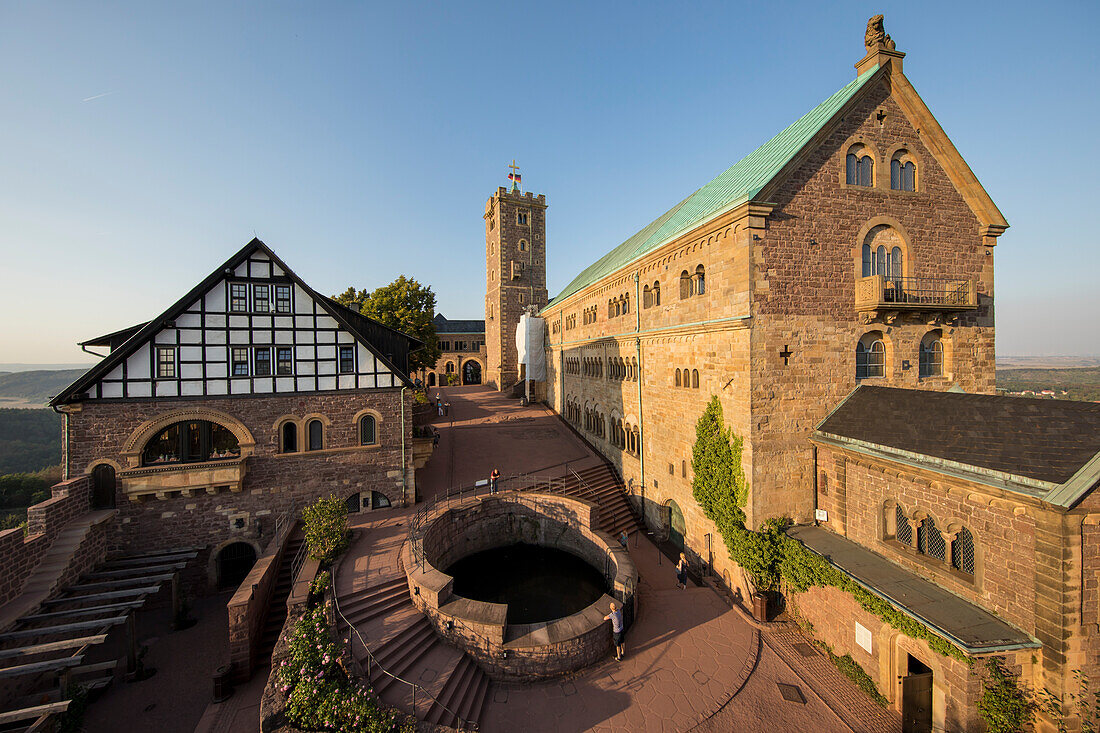 Bergfried and Palas of the Wartburg near Eisenach in the light of the setting sun with a view to the cistern in the courtyard., Eisenach, Thuringia, Germany, Europe