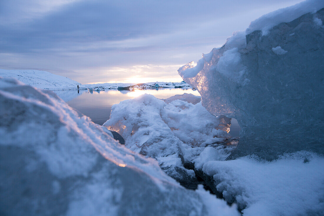 Detail von Eisbrocken und winterliche Landschaft am Gletscher Jökulsárlón (Jokulsarlon) im letzten Licht des Tages, Island, Iceland, Europa
