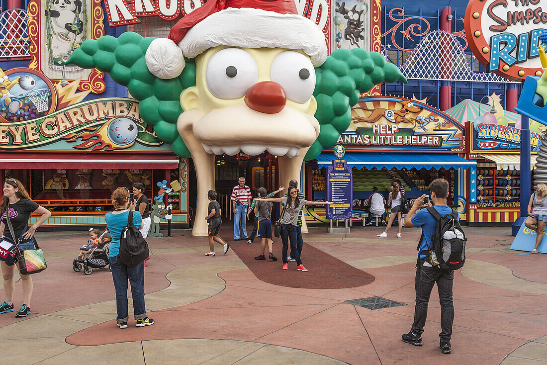 Park guests pose for pictures in front of the Krustyland attraction at Universal Studios theme park in Orlando, Florida.,X2I-2166877 - © - Ron Buskirk