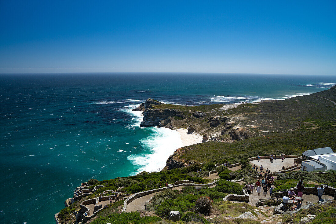Rückblick auf die Kap-Halbinsel, mit Touristen, die vom Leuchtturm am Cape Point, nahe Kapstadt, Südafrika, Afrika, hinuntergehen