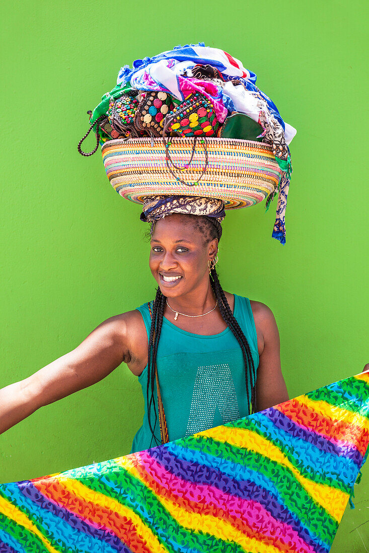 Lokale Frau mit Korb auf dem Kopf Verkauf von Souvenir Schals und Schmuck, Espargos, Santa Maria, Sal Insel, Kap Verde, Afrika