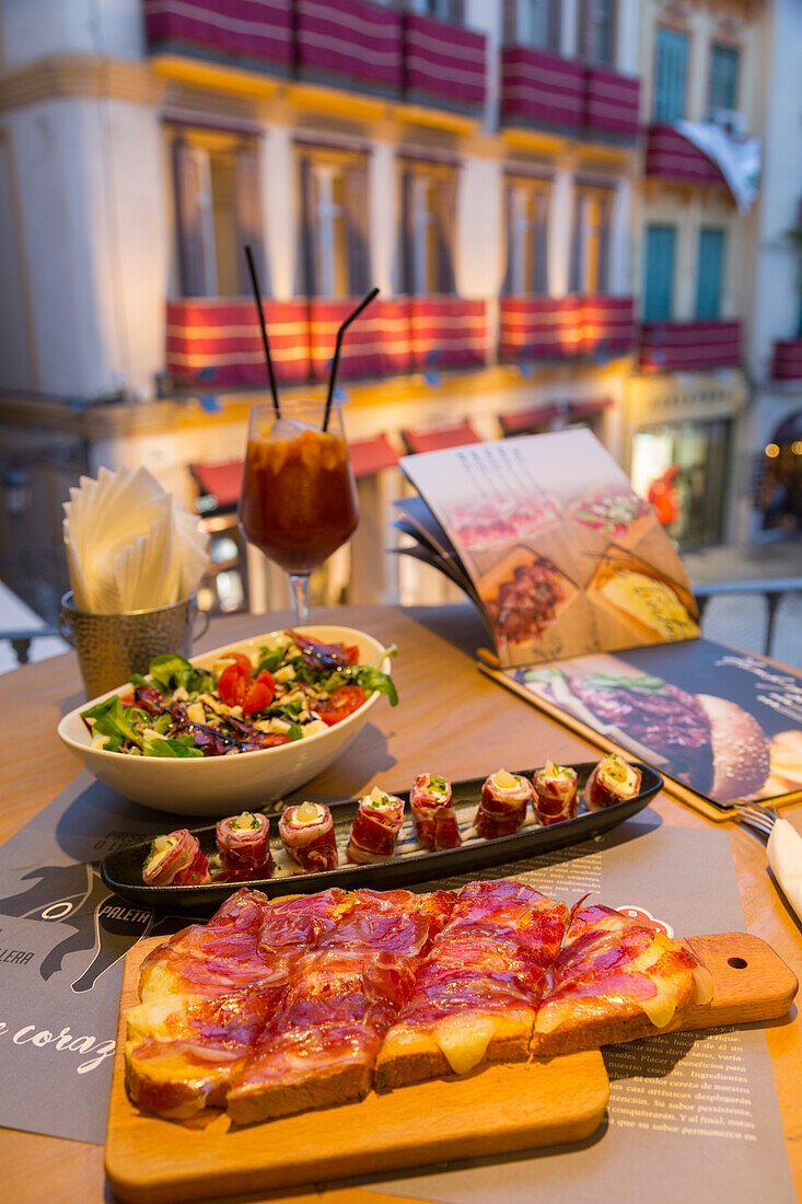 View of traditional Spanish tapas overlooking Plaza del Siglo at dusk, Malaga, Costa del Sol, Andalusia, Spain, Europe