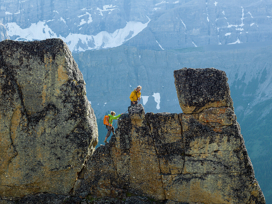 Mountaineering couple ascend rock pinnacle, mountains