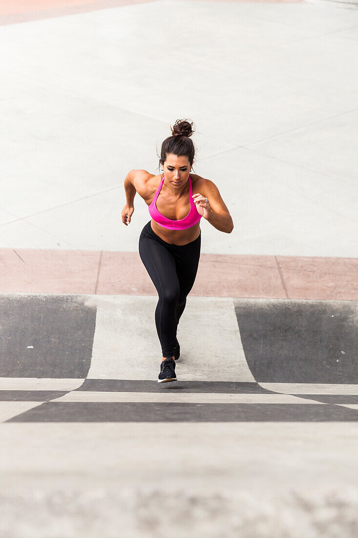 Fit Woman Running Up A Wall In The City Wearing Sports Bra