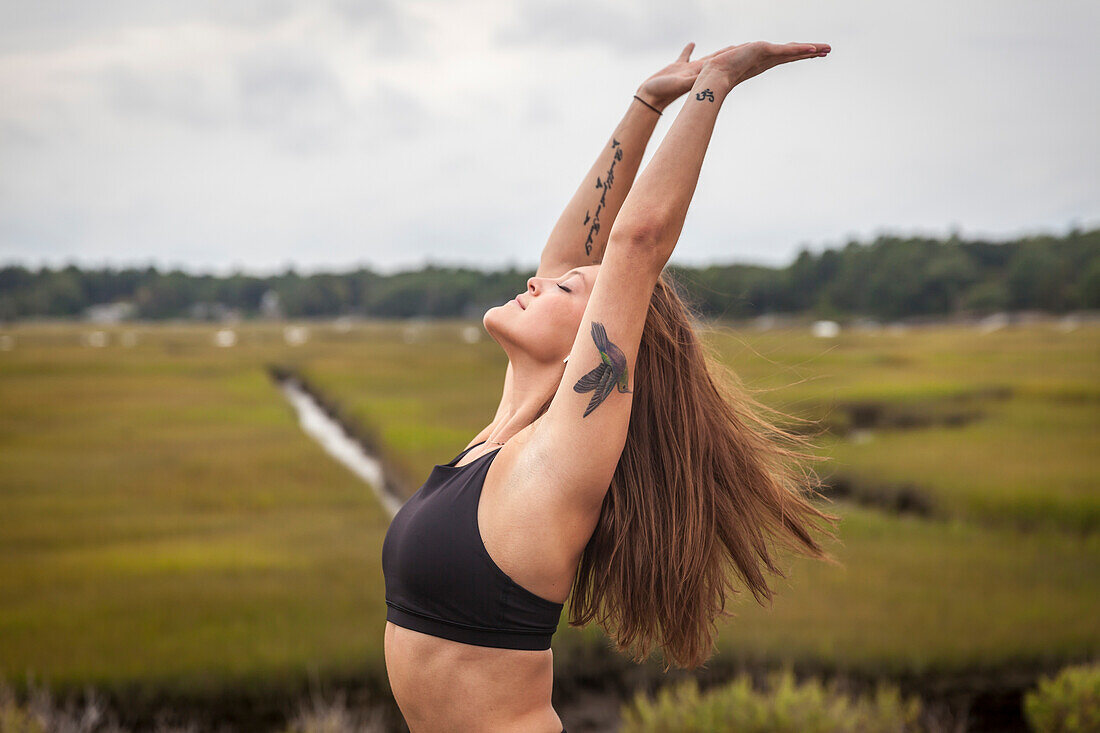 Frau, die Yoga lehnt zurück in einem Backbend draußen auf einer Yogamatte