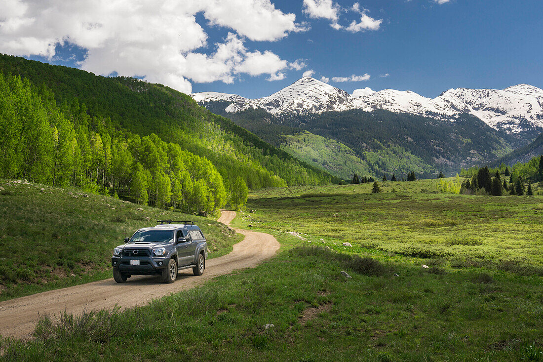 Truck driving on a small dirt mountain road during the spring