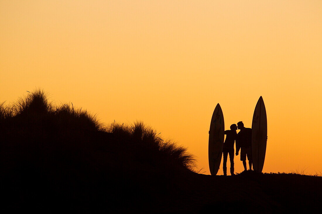 Silhouette Of A Couple Kissing After Surf