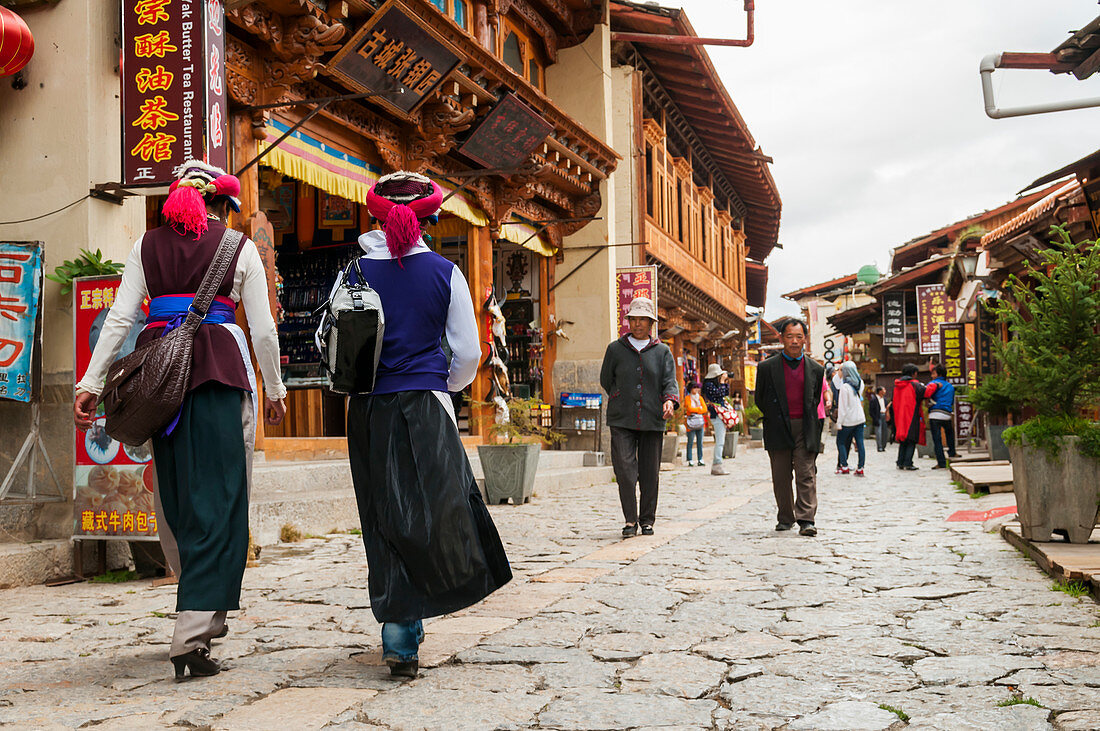 'An ancient street from Shangrila's old town, two women from a minority group walking; Shangri-La, Yunnan province, China'
