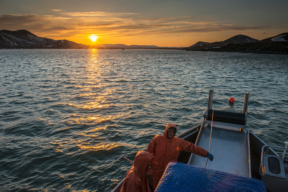 Die Sonne geht über die Kulukak-Bucht in der Bristol-Bucht-Region, als eine kommerzielle Fischermannschaft eine Pause einbringt, Südwesten Alaskas, USA