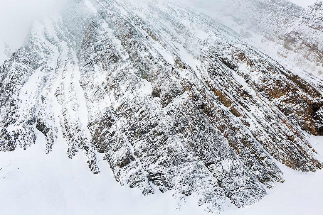 'Nahaufnahme eines schneebedeckten Berggesichtes mit Linienmuster von Felsformation; Kananaskis Land, Alberta, Kanada'