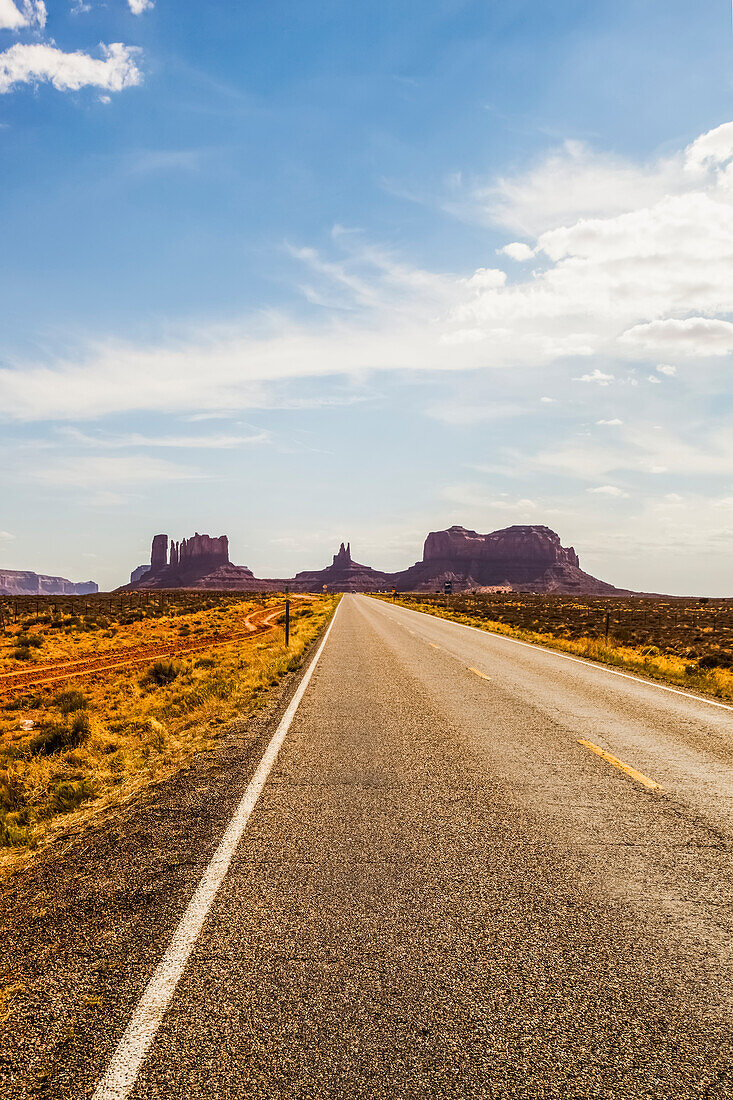'A road leading to rugged rock formations in the desert; Arizona, United States of America'