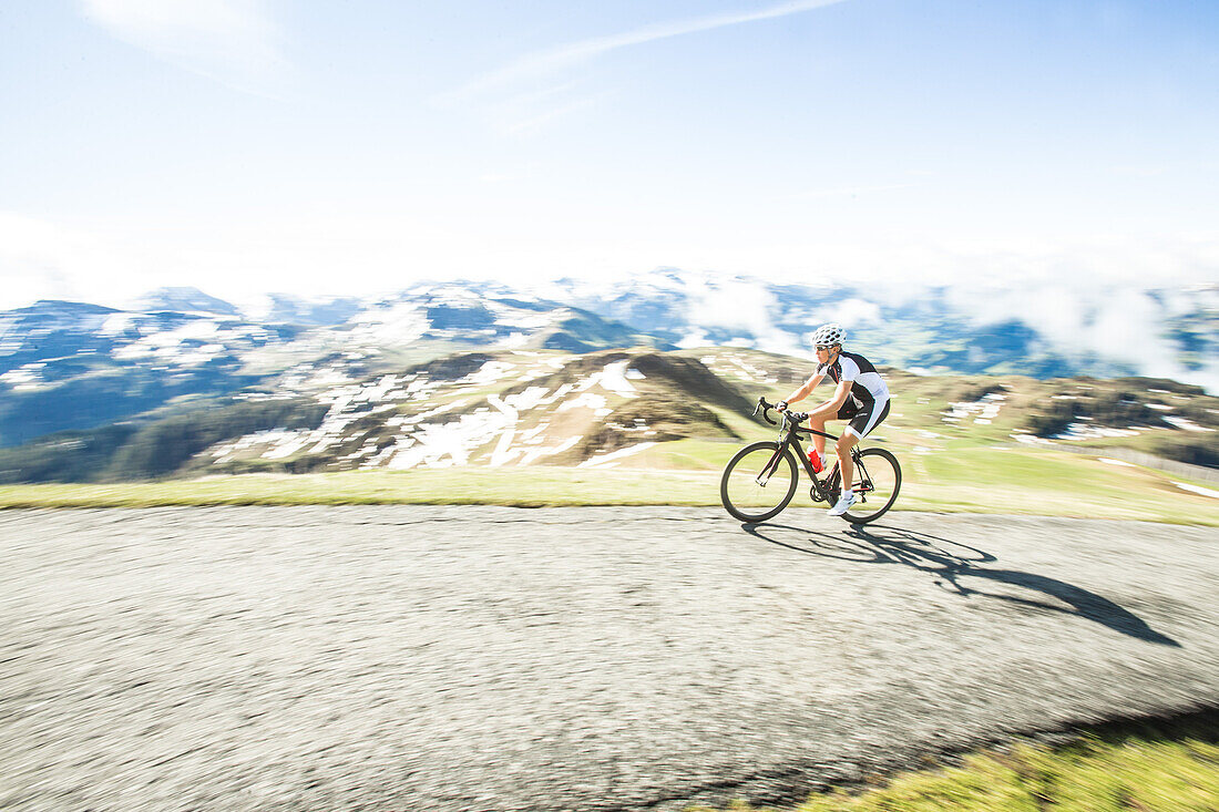 Young woman on her racing cycle in the Kitzbühler Alps, Kitzbühlerhorn, Tyrol, Austria