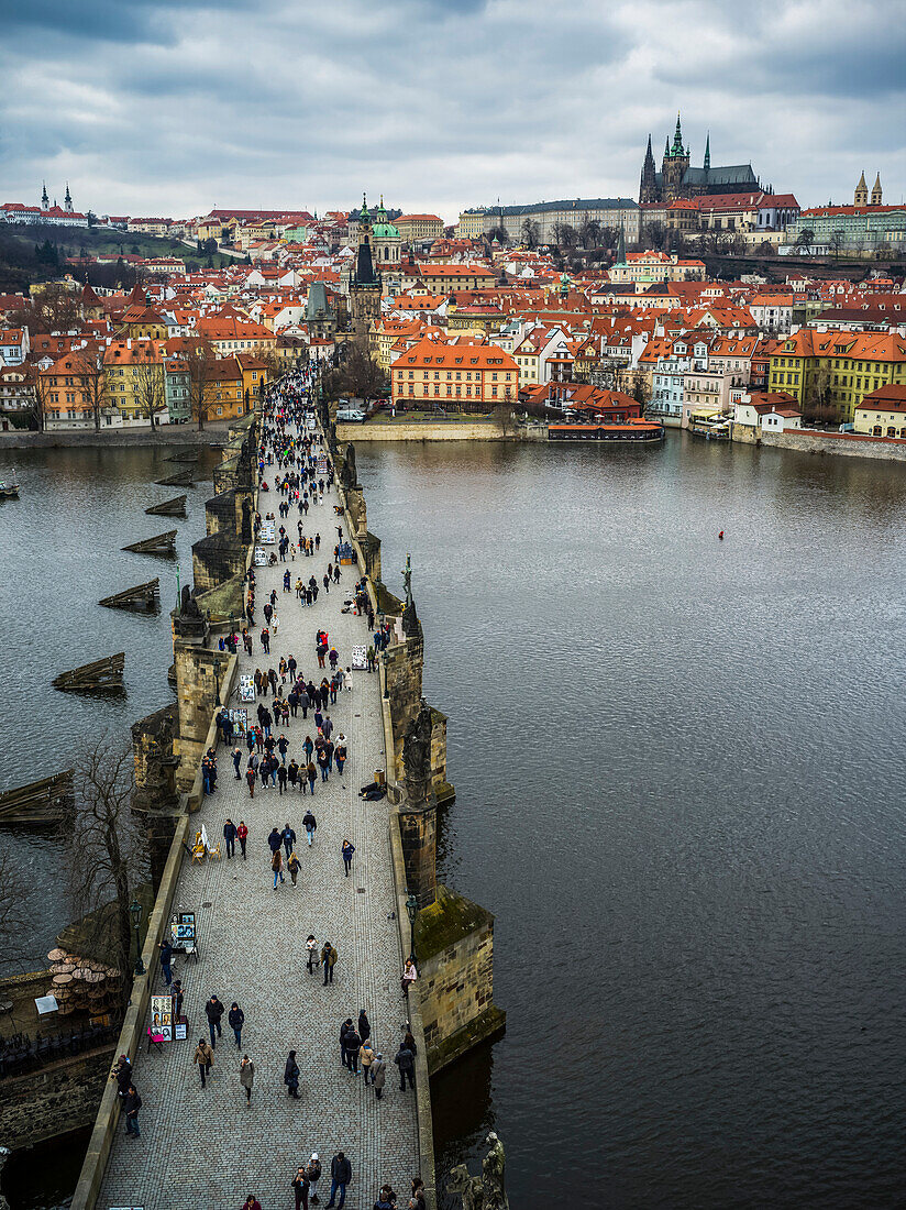 'Pedestrians on Charles Bridge over the Vltava River and Prague Castle in the distance; Prague, Czech Republic'