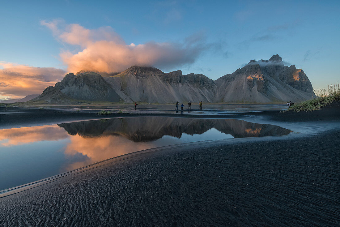 'Leute, die die schöne Landschaft von Stokknes oder Vestrahorn bei Sonnenuntergang entlang der Südostküste von Island fotografieren; Island'